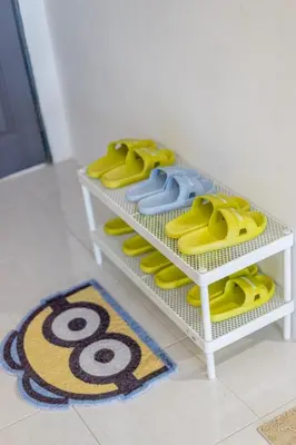 a white shelf with yellow and blue shoes on it at Minion Family Adventure Homestay in Cameron Highlands Clover Home 6-30 in Brinchang