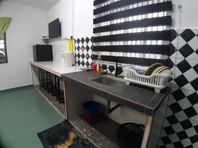 a kitchen with a sink and a black and white wall at Mukhriz 2 Roomstay in Kulim
