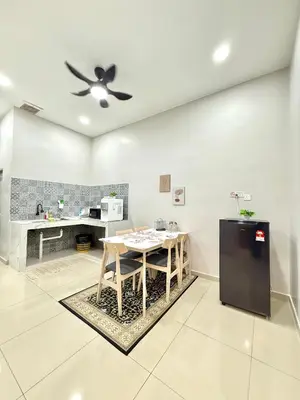 a kitchen with a table and a black refrigerator at SFS Family Homestay Kulim in Kulim
