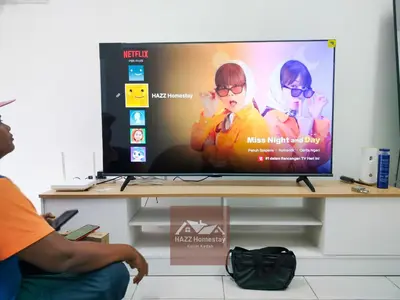 a man sitting in front of a television screen at HAZZ Homestay Puncak Ihsan in Kulim
