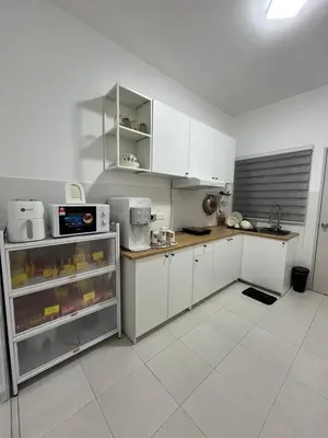 a kitchen with white cabinets and a counter top at KN Homestay in Butterworth