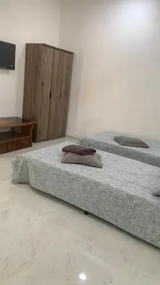 two beds sitting next to each other in a room at Bilik Ubaidillah in Gerik