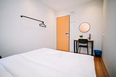a bedroom with a bed and a table with a chair at Swing & Pillows - Armenian Victoria , Georgetown Penang in George Town