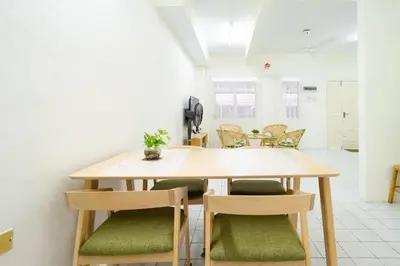 a wooden table and chairs in a room at Sweet 9ight Menglembu Falim Homestay in Ipoh