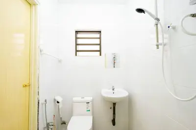 a white bathroom with a toilet and a sink at Sweet 9ight Menglembu Falim Homestay in Ipoh