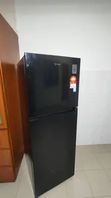 a black refrigerator with a sticker on it in a kitchen at 66 Homestay 5 Min to Leaning Tower in Teluk Intan