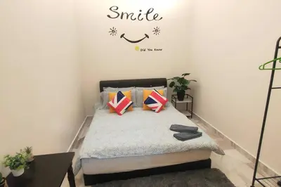 a bedroom with a bed with a smile sign on the wall at 66 Homestay 5 Min to Leaning Tower in Teluk Intan