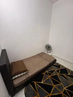 a small bed in a corner of a room at Mom House in Ipoh