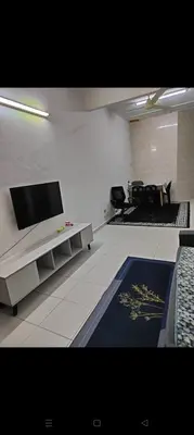 a living room with a flat screen tv on a wall at Mom House in Ipoh