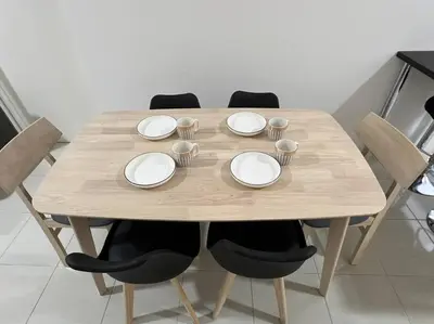 a wooden table with white plates and cups on it at Ipoh Town Anderson Hani Suite 4paxs 1R1B in Ipoh