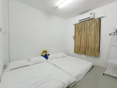 a small bedroom with a bed with white sheets at 9pax -Taman Bagan Butterworth -Budget Homestay in Butterworth