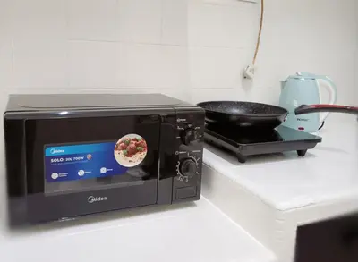 a toaster oven on a kitchen counter with a pan of food at 9pax -Taman Bagan Butterworth -Budget Homestay in Butterworth