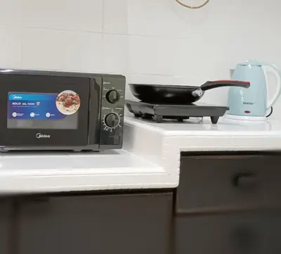 a microwave sitting on top of a kitchen counter at 9pax -Taman Bagan Butterworth -Budget Homestay in Butterworth