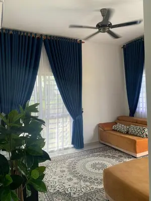 a bedroom with blue curtains and a large window at HomeStay Damia in Teluk Intan