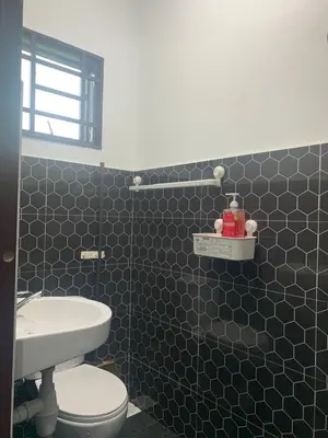 a bathroom with a white toilet and a sink at HomeStay Damia in Teluk Intan
