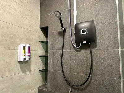 a shower in a bathroom with a camera on the wall at Superb Airport 2BR Suite# Straits Intl# MsgChair in Bayan Lepas