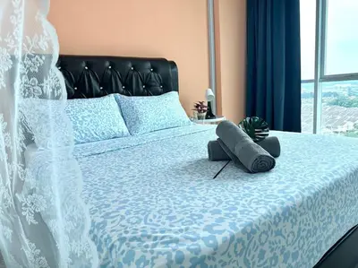 a bedroom with a bed with a blue and white comforter at Superb Airport 2BR Suite# Straits Intl# MsgChair in Bayan Lepas