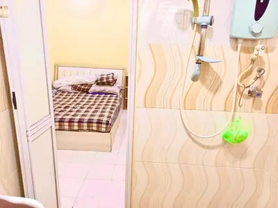 a bathroom with a shower with a bed in it at Lavender Homestay Tanjung Malim in Tanjung Malim