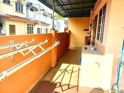 a hallway of a building with orange walls and a sink at Lavender Homestay Tanjung Malim in Tanjung Malim