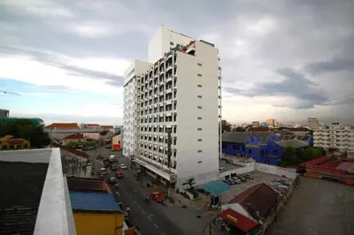 a tall white building in a city with cars at Hotel Malaysia in George Town