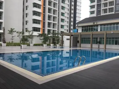 a large swimming pool in a building with tall buildings at The Rain Homestay Meru Raya in Ipoh