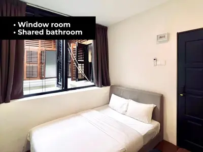 a bedroom with a bed with a window room shared bathroom at INN Lebuh Melayu in George Town