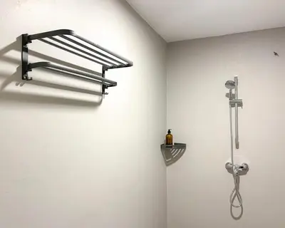 a shower in a bathroom with a wall at INN Lebuh Melayu in George Town