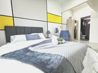 a bedroom with a large white bed with a plant on it at Meritus Seaview Apartment in Perai