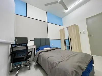 a bedroom with a bed and a desk and a chair at Meritus Seaview Apartment in Perai