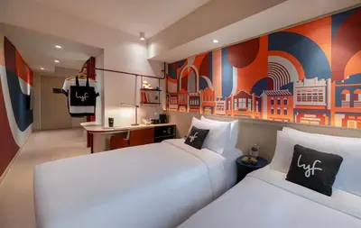 a hotel room with two beds and a desk at lyf Georgetown Penang in George Town
