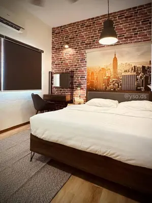a bedroom with a large bed and a brick wall at New Grand Muji Style Villa at Central Penang 16pax in Bukit Lada