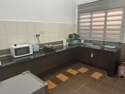 a kitchen with a sink and a microwave on a counter at SakuZa Homestay in Slim River
