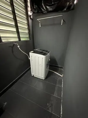 a bathroom with a trash can on a tiled floor at SakuZa Homestay in Slim River