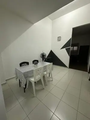 a dining room with a white table and chairs at SakuZa Homestay in Slim River