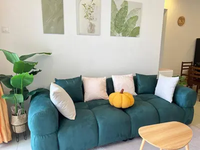 a green couch with a pumpkin on it in a living room at G Home 1 - Ipoh City Center Majestic 2R2B in Ipoh