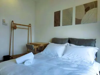 a bed with white sheets and pillows in a bedroom at G Home 1 - Ipoh City Center Majestic 2R2B in Ipoh