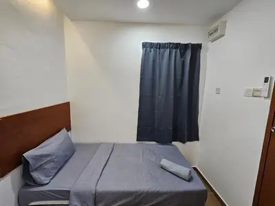 a small bedroom with a bed and a window at New Mawlaya Hotel Penang in Gelugor