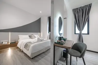 a bedroom with a bed and a desk and a chair at Saturn Hotel in George Town