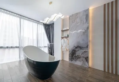 a modern bathroom with a black and white tub at Saturn Hotel in George Town