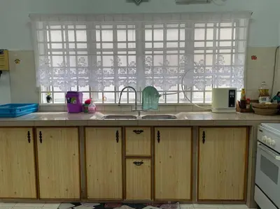 a kitchen with wooden cabinets and a sink and a window at 4BR 2Storey Terrace Homestay at Bukit Jambul by SK Vacation Homes in Bayan Lepas