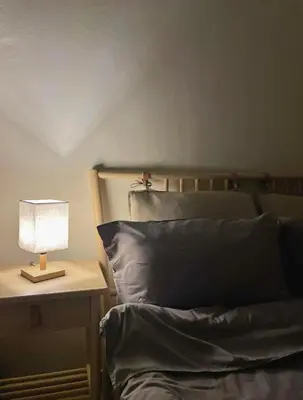 a lamp on a night stand next to a bed at Mizu Homestay Kea Farm 10mins to BOH in Cameron Highlands