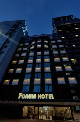 a tall black building with a hotel sign on it at Forum Hotel Penang in George Town