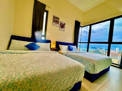a hotel room with two beds and a large window at Family House In Georgetown a27 in Jelutong