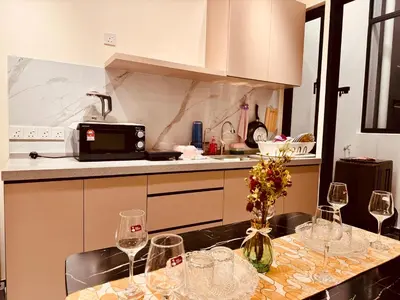 a kitchen with a table with wine glasses on it at Family House In Georgetown a27 in Jelutong