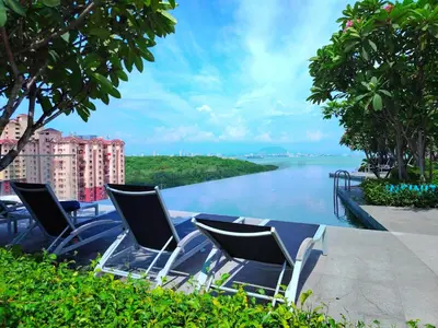 a group of chairs sitting next to a body of water at Premium Familystay Urban Suites-3BR 14 pax in Jelutong
