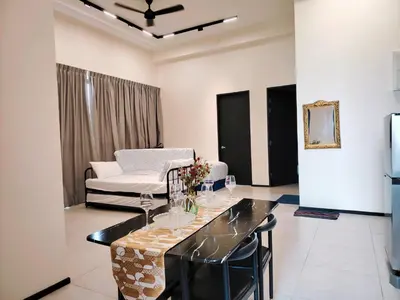 a living room with a table and a couch at Premium Familystay Urban Suites-3BR 14 pax in Jelutong
