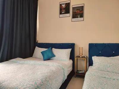 a bedroom with two beds with blue pillows at Premium Familystay Urban Suites-3BR 14 pax in Jelutong