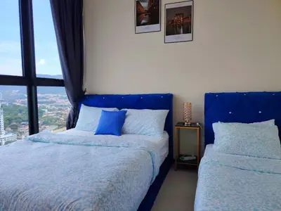 a bedroom with two beds with blue pillows and a window at Premium world-class House-Sea & City View Netflix in Jelutong