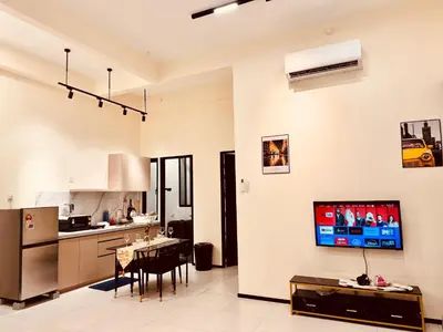 a kitchen and dining room with a tv on the wall at Premium world-class House-Sea & City View Netflix in Jelutong