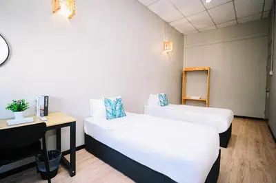 a small room with two beds and a desk at Swing & Pillows - 87 Chulia St, Georgetown Penang in George Town